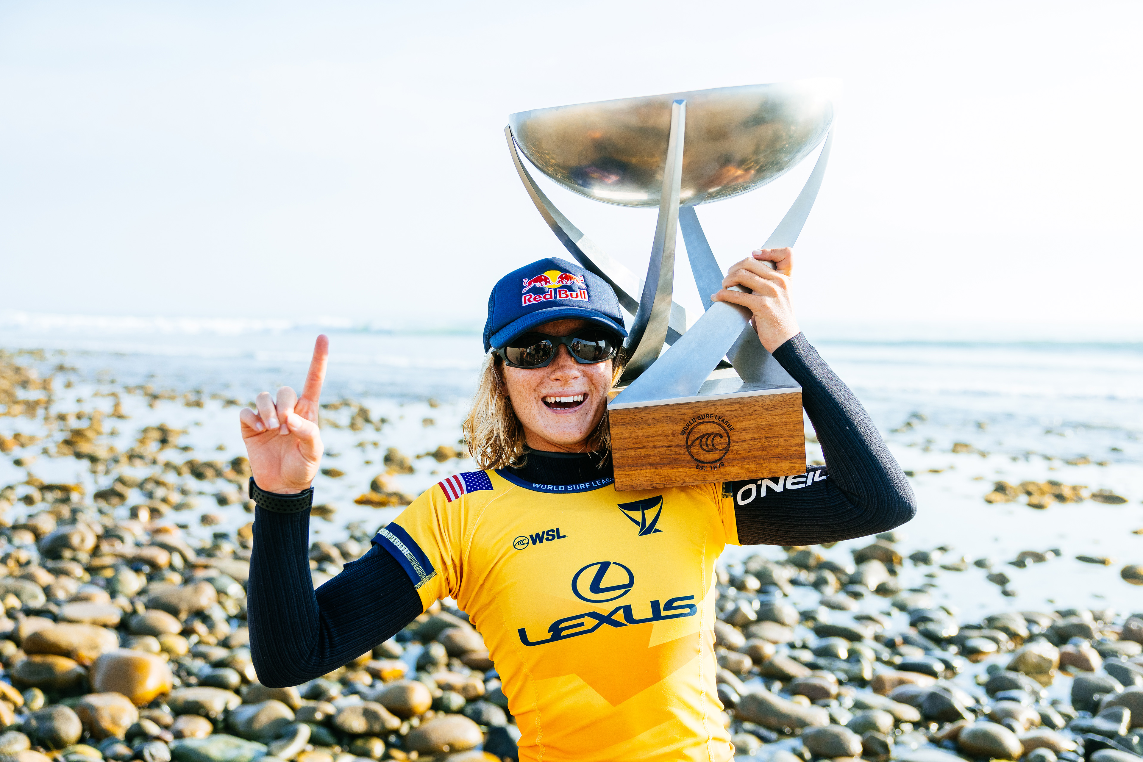 Caitlin Simmers amarradona com o troféu de melhor surfista do mundo.