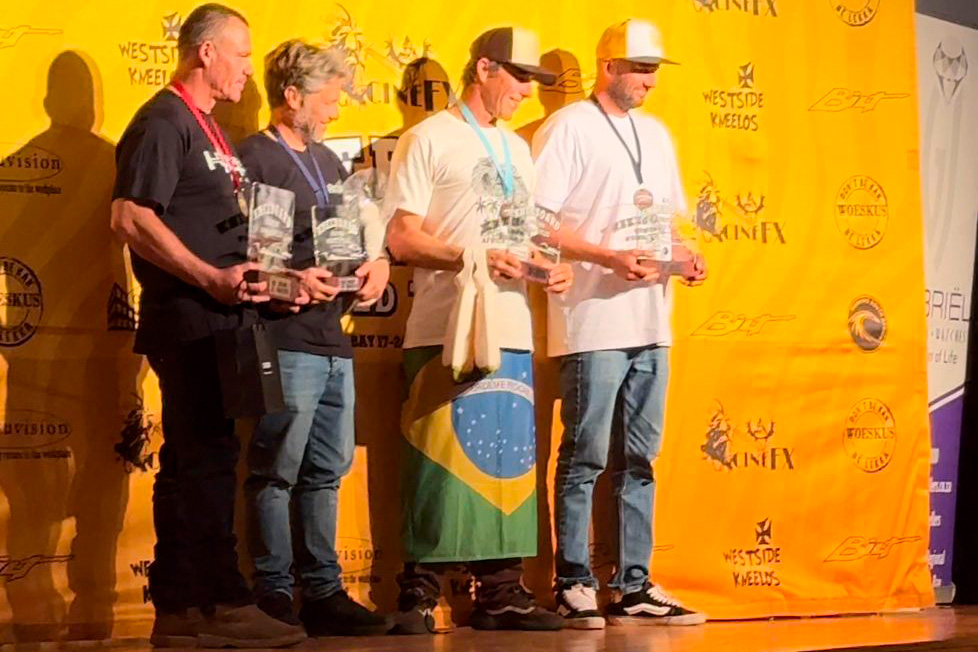 Eduardo Machado comemora a medalha de bronze com a bandeira do Brasil.