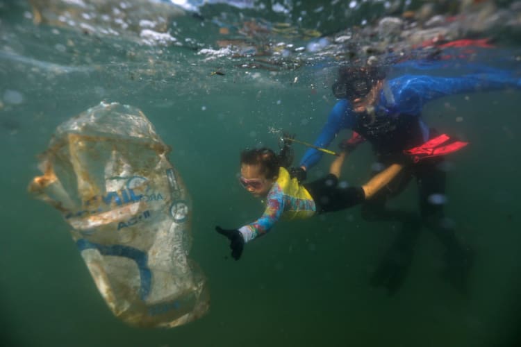 Ricardo Gomes com filha Nina em ação de limpeza no Rio.